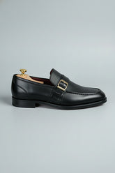 Black leather dress shoes with buckle detail, perfect for formal wear and business.